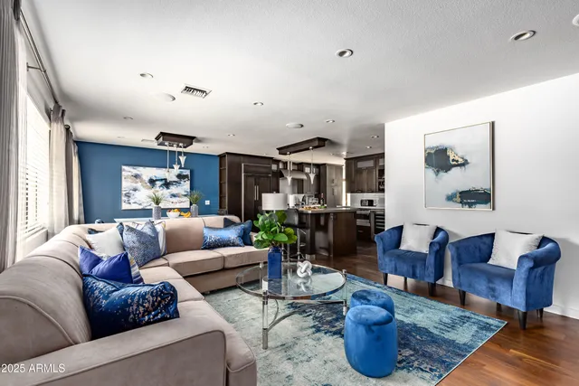 a living room with furniture kitchen view and a window