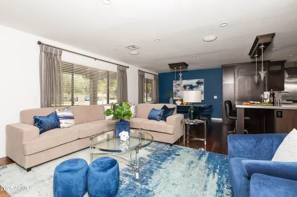 a living room with furniture kitchen view and a large window