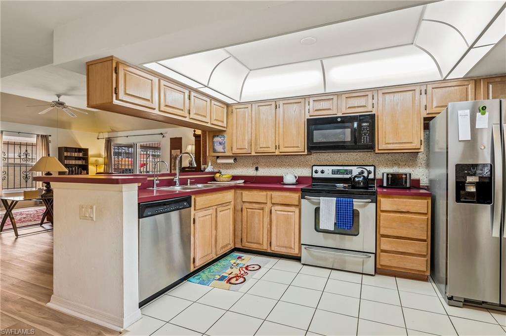 156 Sabal Lake Drive Naples, FL 34104 - Photo 11 of 40 a kitchen with stainless steel appliances granite countertop a stove top oven a sink a counter top space and cabinets