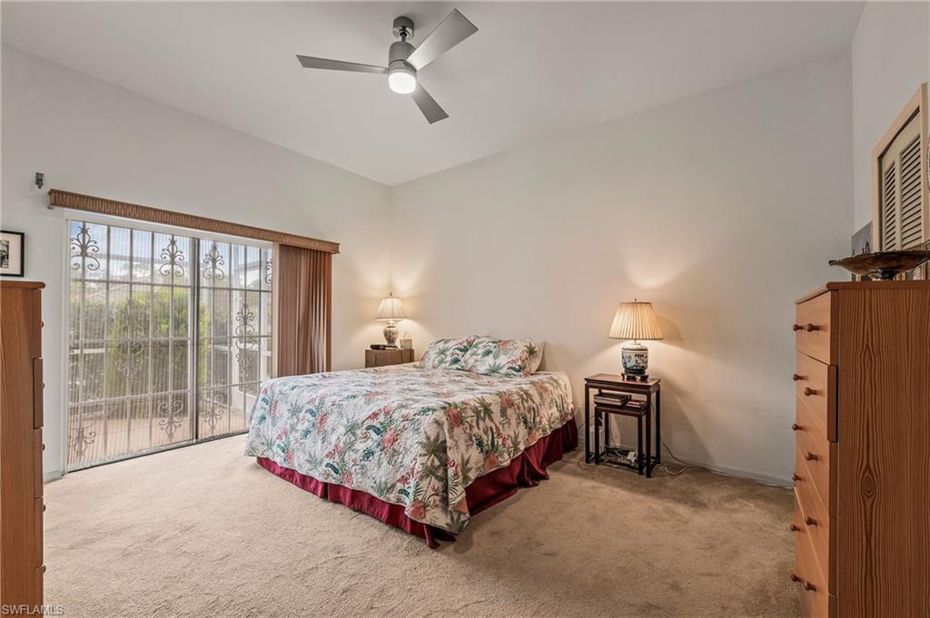 156 Sabal Lake Drive Naples, FL 34104 - Photo 14 of 40 a bedroom with a bed and a large window