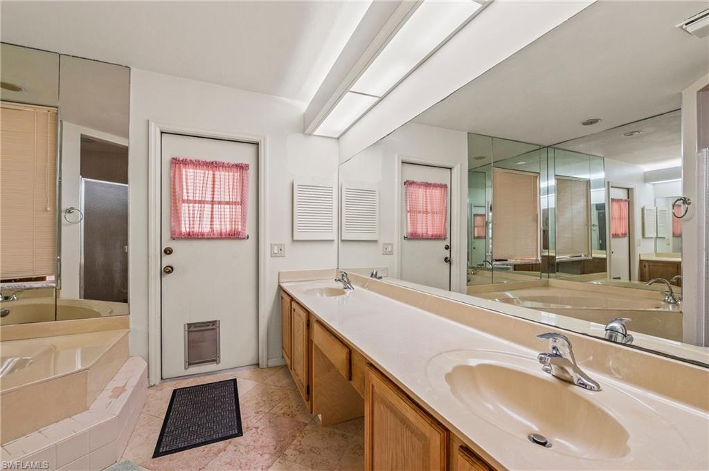 156 Sabal Lake Drive Naples, FL 34104 - Photo 16 of 40 a bathroom with a tub sink and mirror