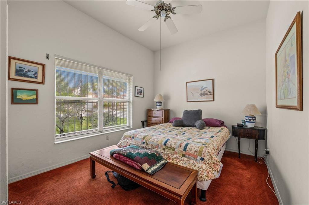 156 Sabal Lake Drive Naples, FL 34104 - Photo 17 of 40 a bedroom with a bed table chair and a window