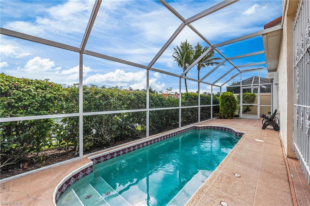 156 Sabal Lake Drive Naples, FL 34104 - Photo 2 of 40 a view of a swimming pool with a porch