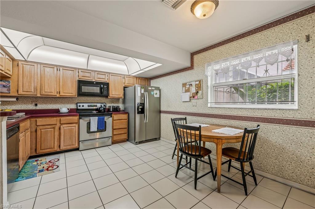 156 Sabal Lake Drive Naples, FL 34104 - Photo 10 of 40 a kitchen with stainless steel appliances granite countertop a stove top oven a sink dishwasher and a refrigerator