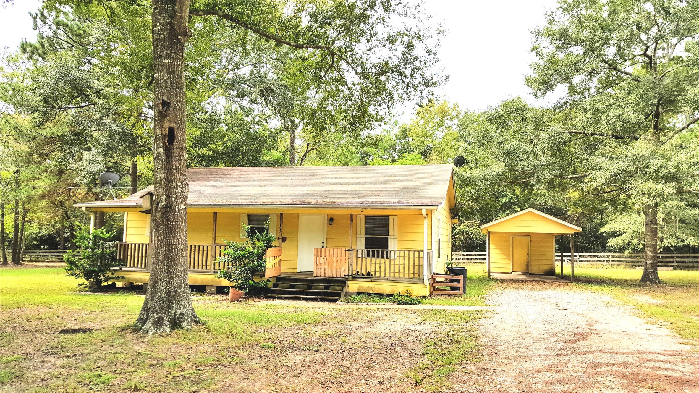 12105 Old County Road Willis, TX 77378 - Photo 2 of 13 a view of house with yard outdoor seating and covered with trees
