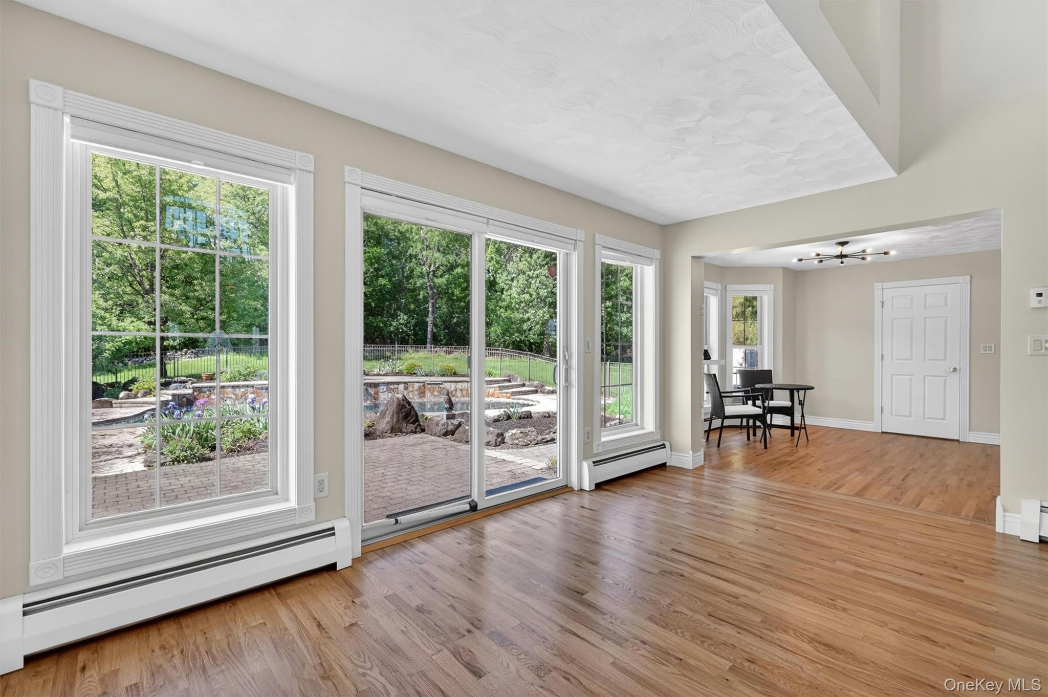 954 Ridgebury Road New Hampton, NY 10958 - Photo 16 of 45 Large windows and glass doors bring the outside in, offering views of the patio, stonework, and backyard retreat.
