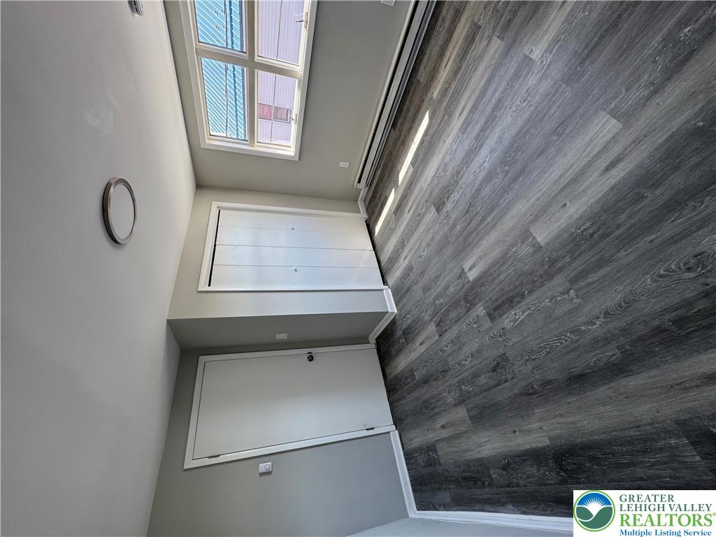 702 Walnut Street, Unit 2 Freeland, PA 18224 - Photo 8 of 8 Upper windows illuminate grey wood-look flooring and clean architectural lines.