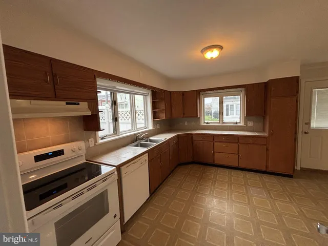a kitchen with stainless steel appliances a stove sink and cabinets