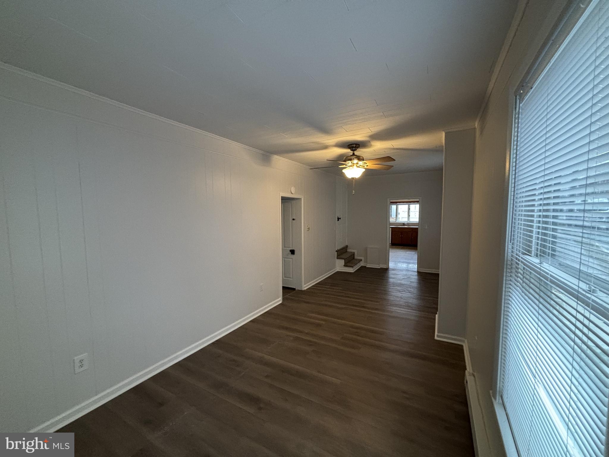 401 Main Street, Unit A Denver, PA 17517 - Photo 6 of 12 a view of a livingroom with wooden floor a ceiling fan and staircase