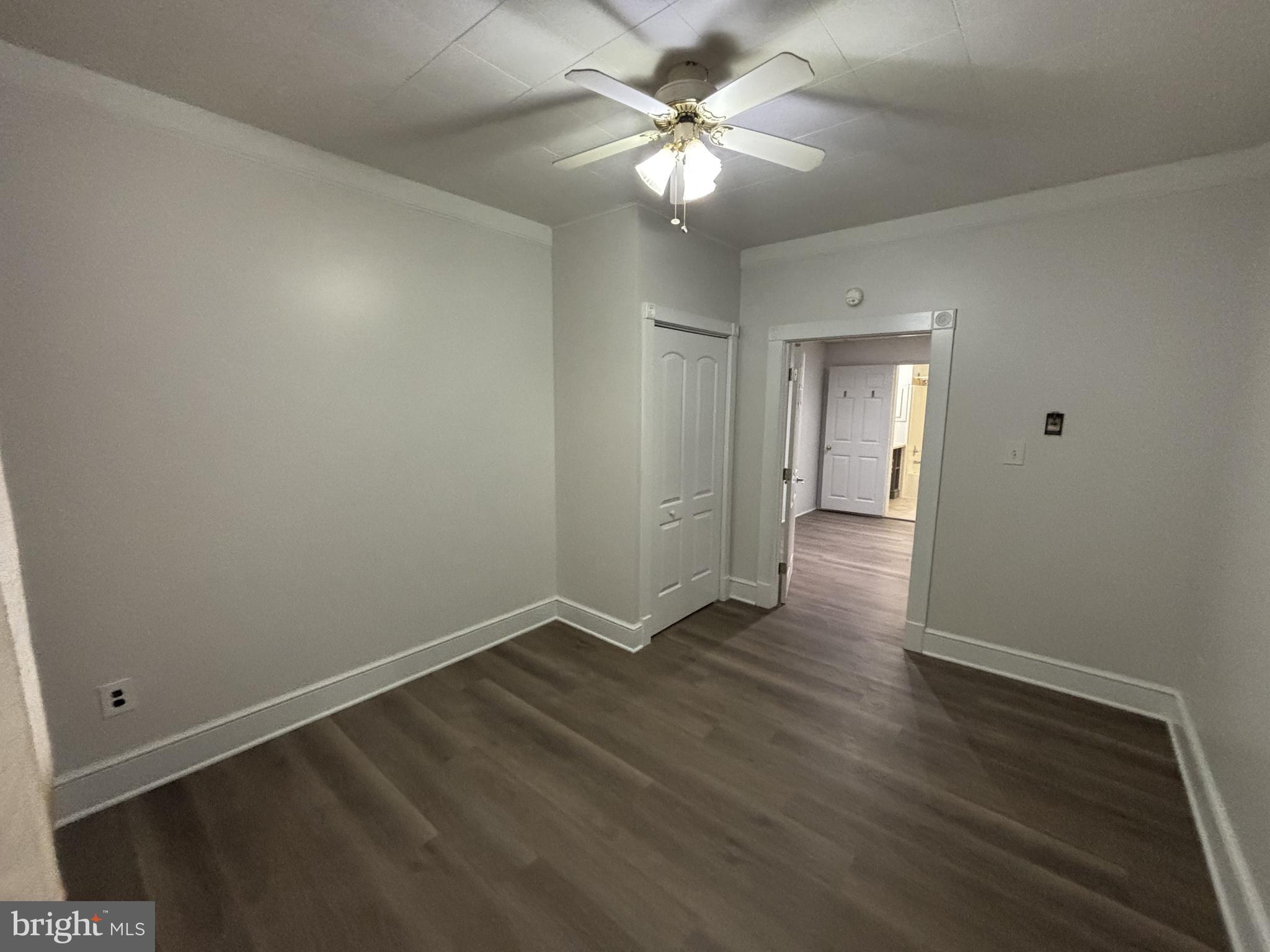401 Main Street, Unit A Denver, PA 17517 - Photo 9 of 12 an empty room with wooden floor and a ceiling fan