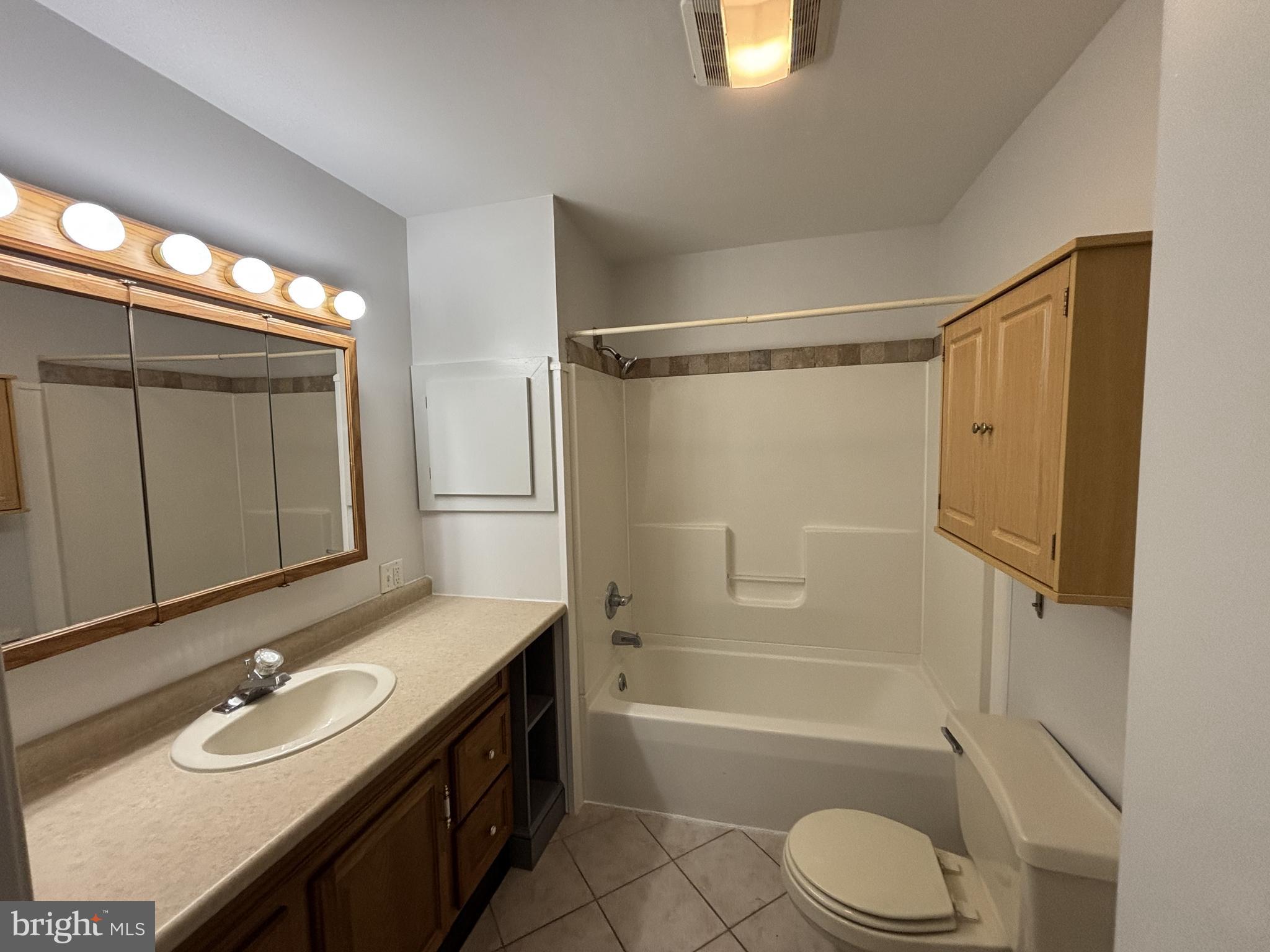 401 Main Street, Unit A Denver, PA 17517 - Photo 10 of 12 a bathroom with a granite countertop sink toilet mirror and shower