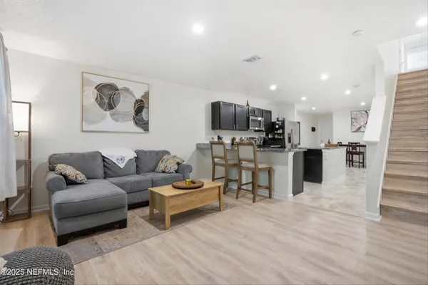 a living room with furniture and kitchen view