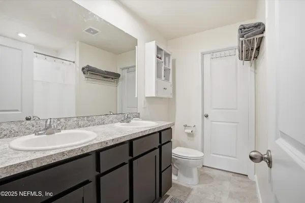 a bathroom with a granite countertop sink toilet a mirror and shower
