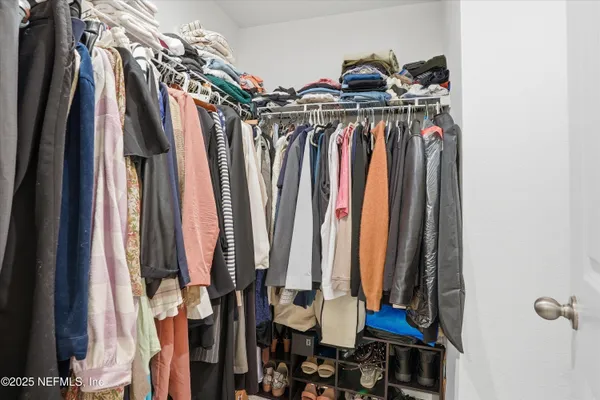 a view of walk in closet with clothes