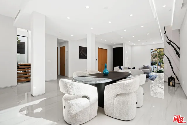 a living room with furniture a large window and a dining table