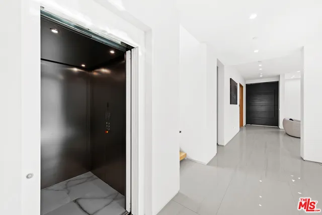 a kitchen with granite countertop a table chairs stove and white cabinets