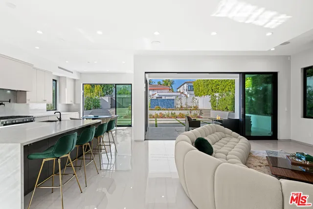 a large white kitchen with a large window and sink