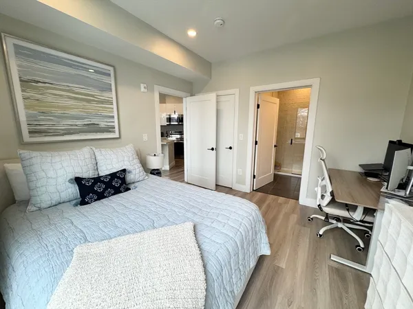a bedroom with a bed and wooden floor