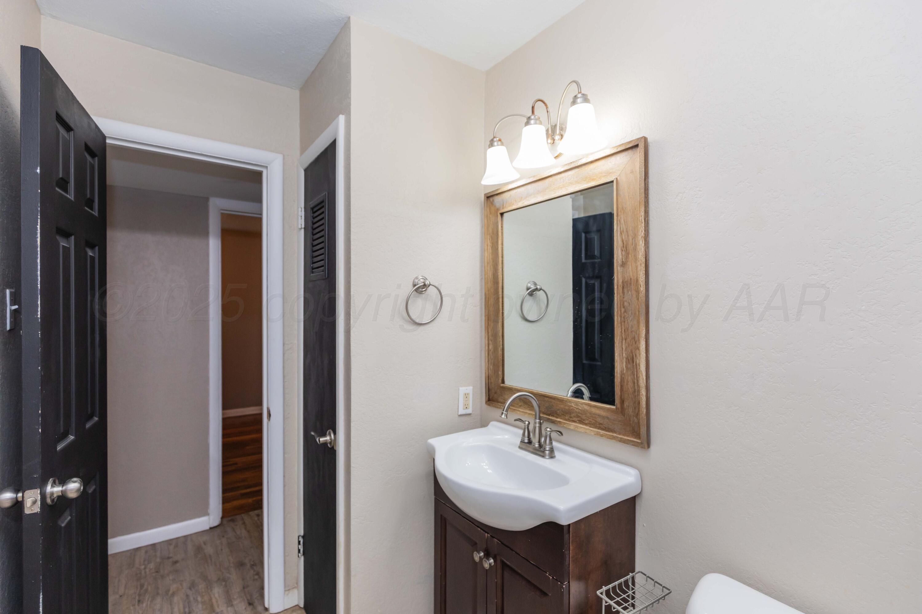 2138 North Sumner Street Pampa, TX 79065 - Photo 19 of 30 a bathroom with a sink and a mirror