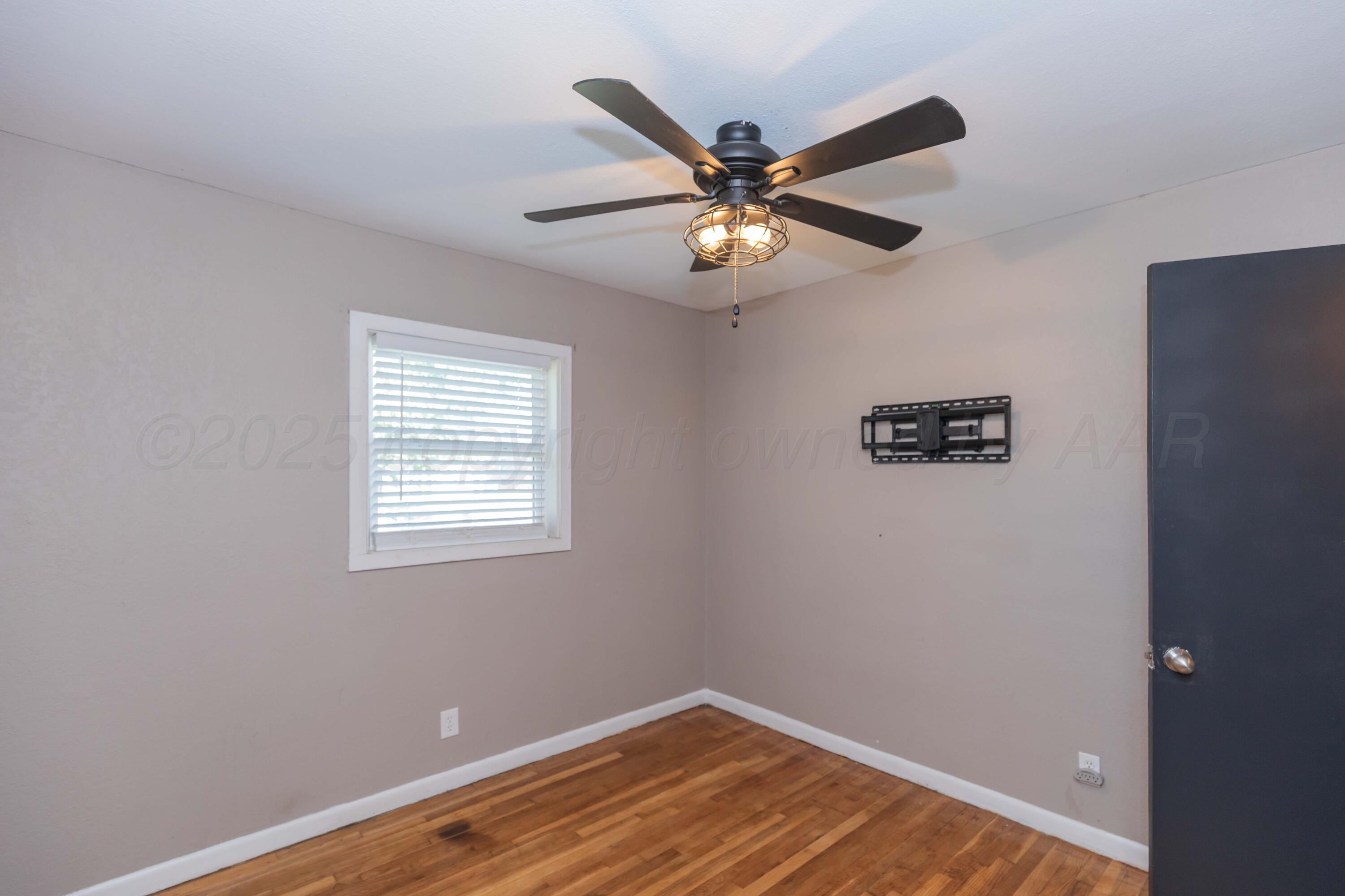 2138 North Sumner Street Pampa, TX 79065 - Photo 27 of 30 an empty room with wooden floor fan and windows
