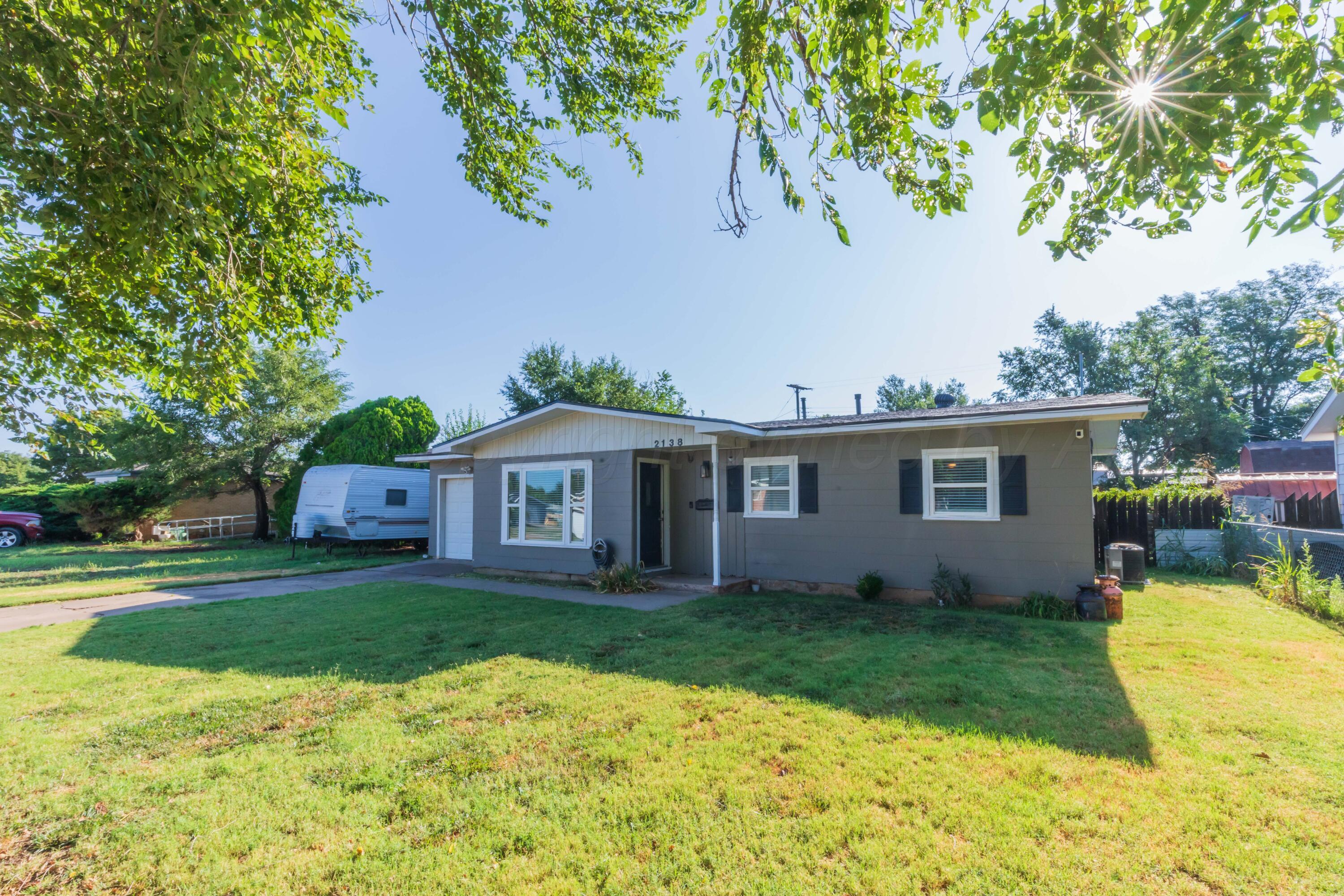 2138 North Sumner Street Pampa, TX 79065 - Photo 3 of 30 a front view of a house with a garden and trees