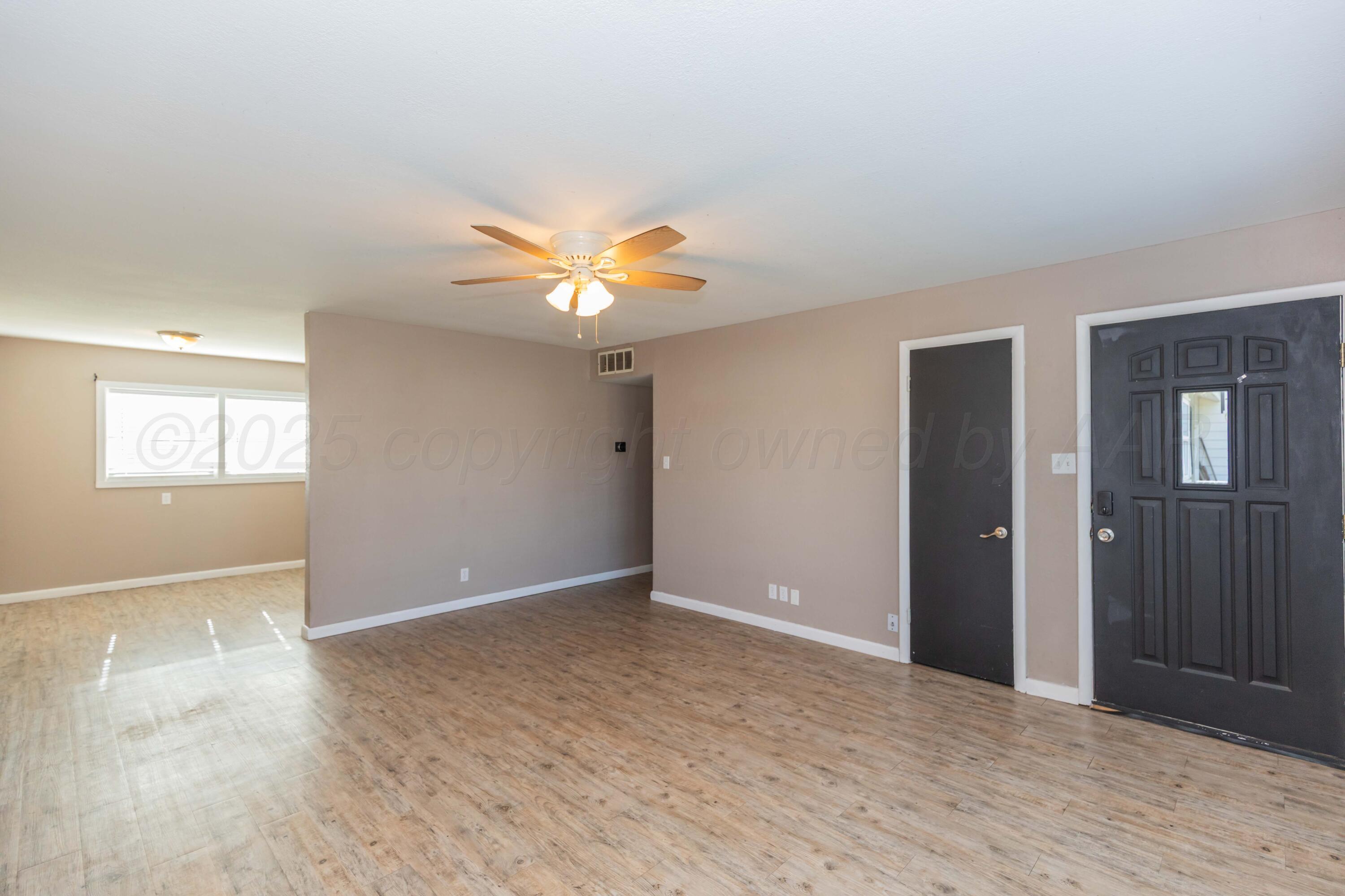 2138 North Sumner Street Pampa, TX 79065 - Photo 4 of 30 wooden floor in an empty room with a window