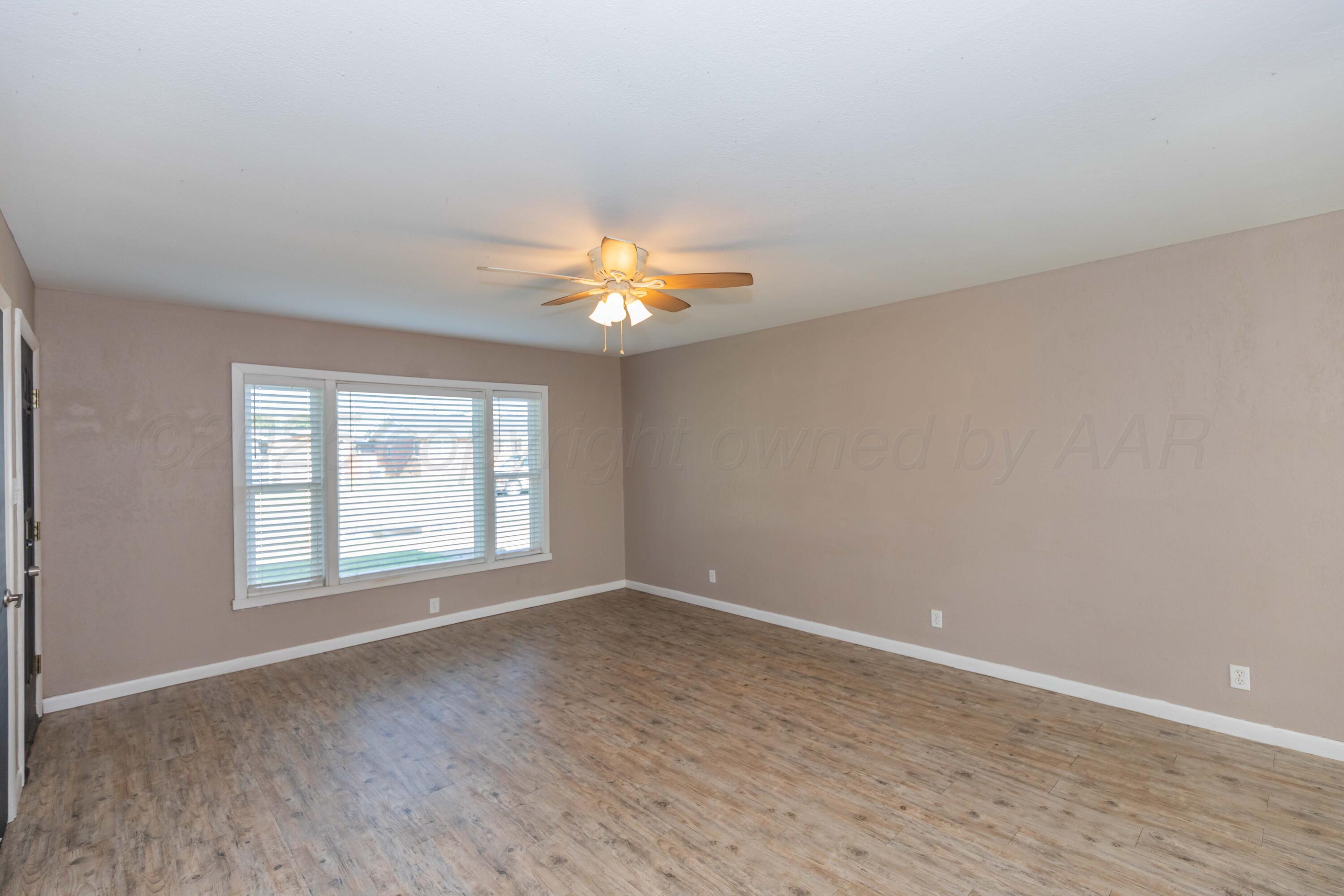 2138 North Sumner Street Pampa, TX 79065 - Photo 5 of 30 wooden floor in an empty room with a window