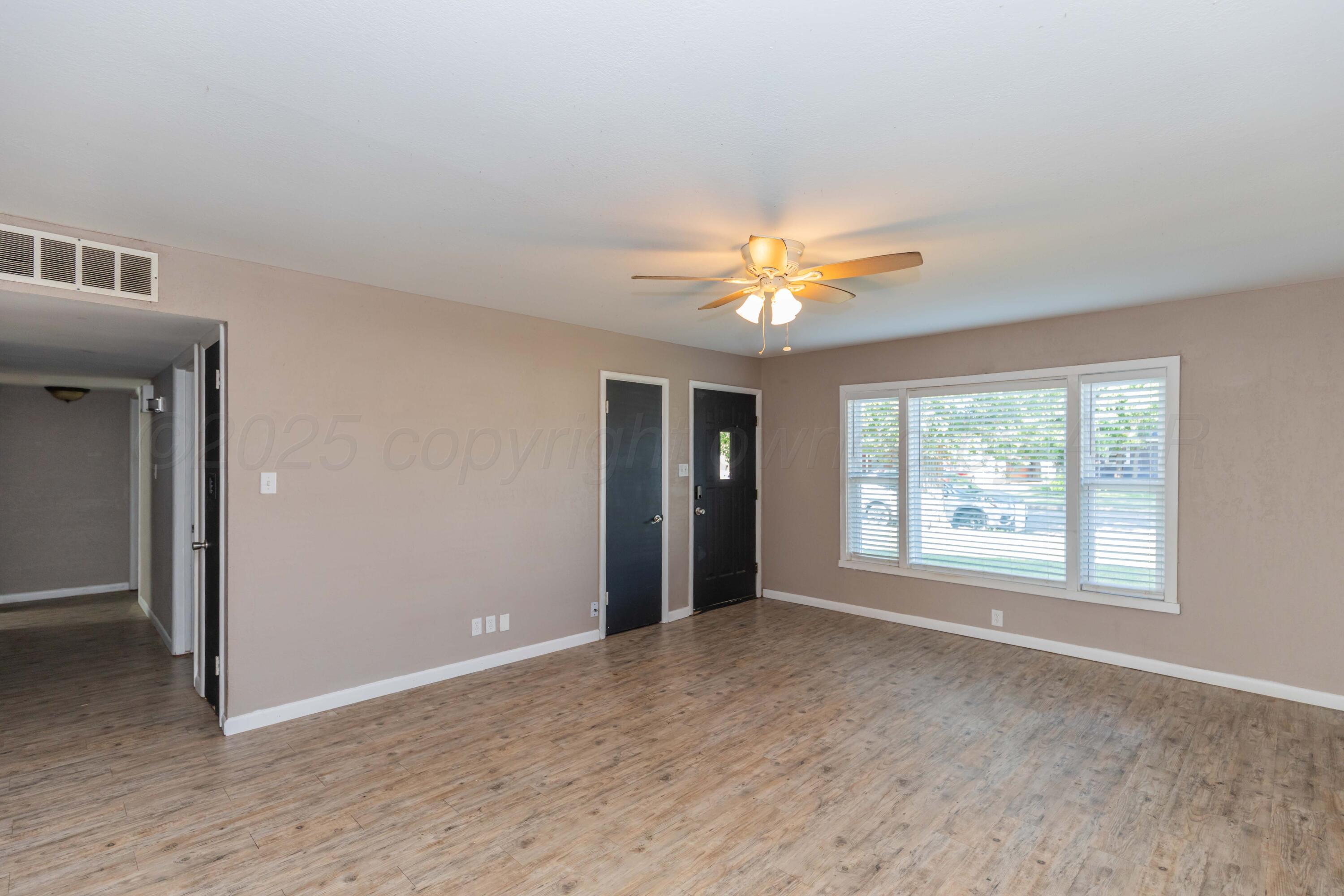 2138 North Sumner Street Pampa, TX 79065 - Photo 7 of 30 a view of an empty room with chandelier fan and fire place