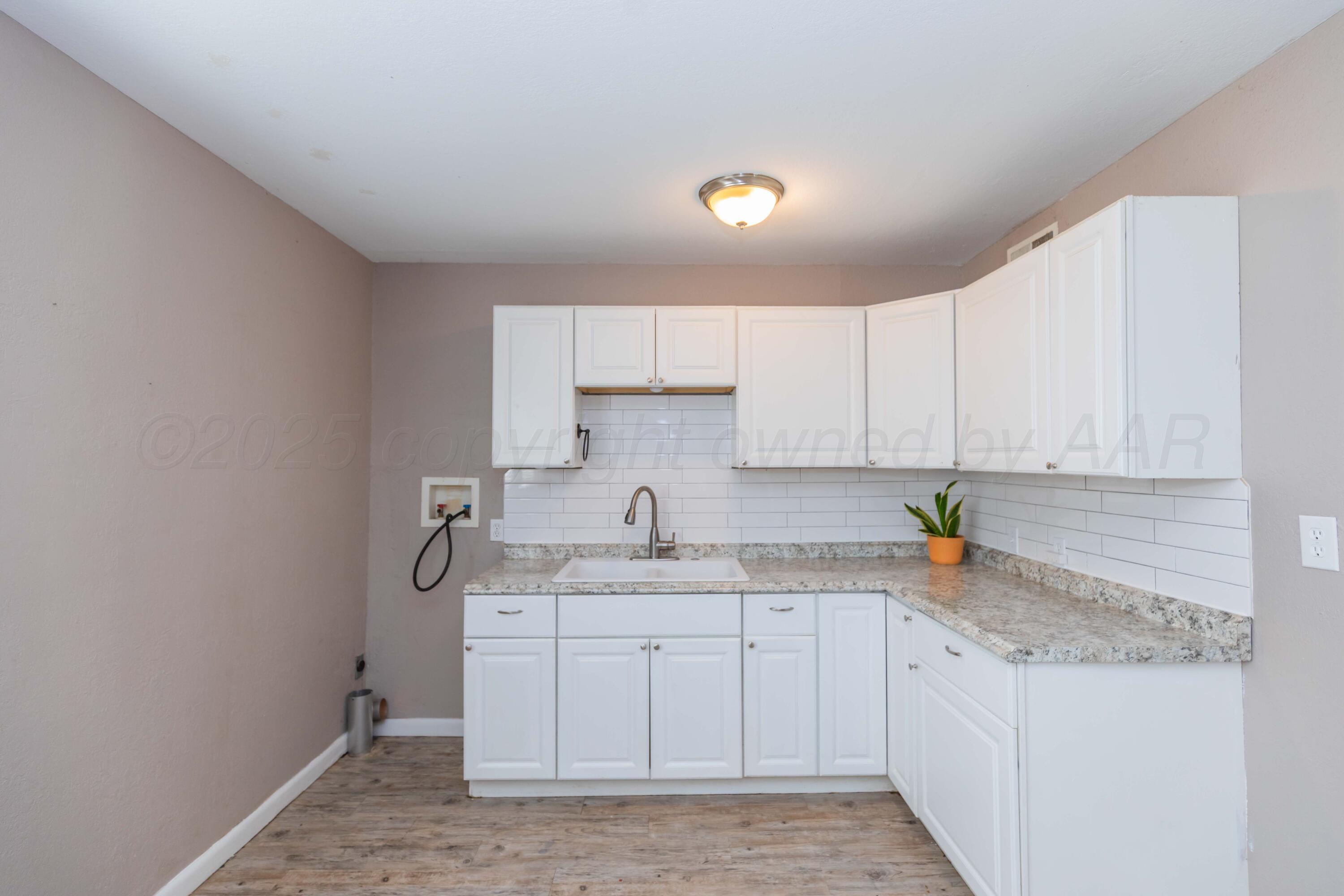 2138 North Sumner Street Pampa, TX 79065 - Photo 8 of 30 a kitchen with stainless steel appliances granite countertop a sink stove and cabinets