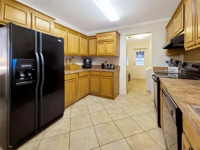 a kitchen with stainless steel appliances granite countertop a refrigerator a stove and a sink