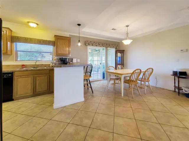 a kitchen with stainless steel appliances granite countertop a sink a stove a dining table and chairs