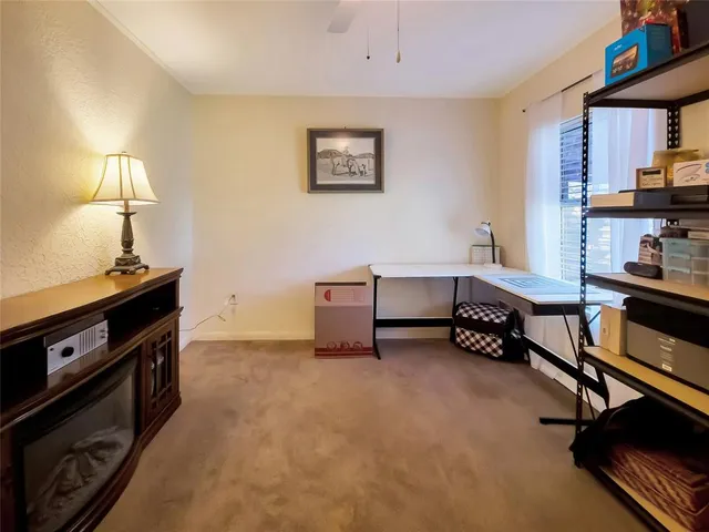 a room with furniture and a lamp on a bookshelf