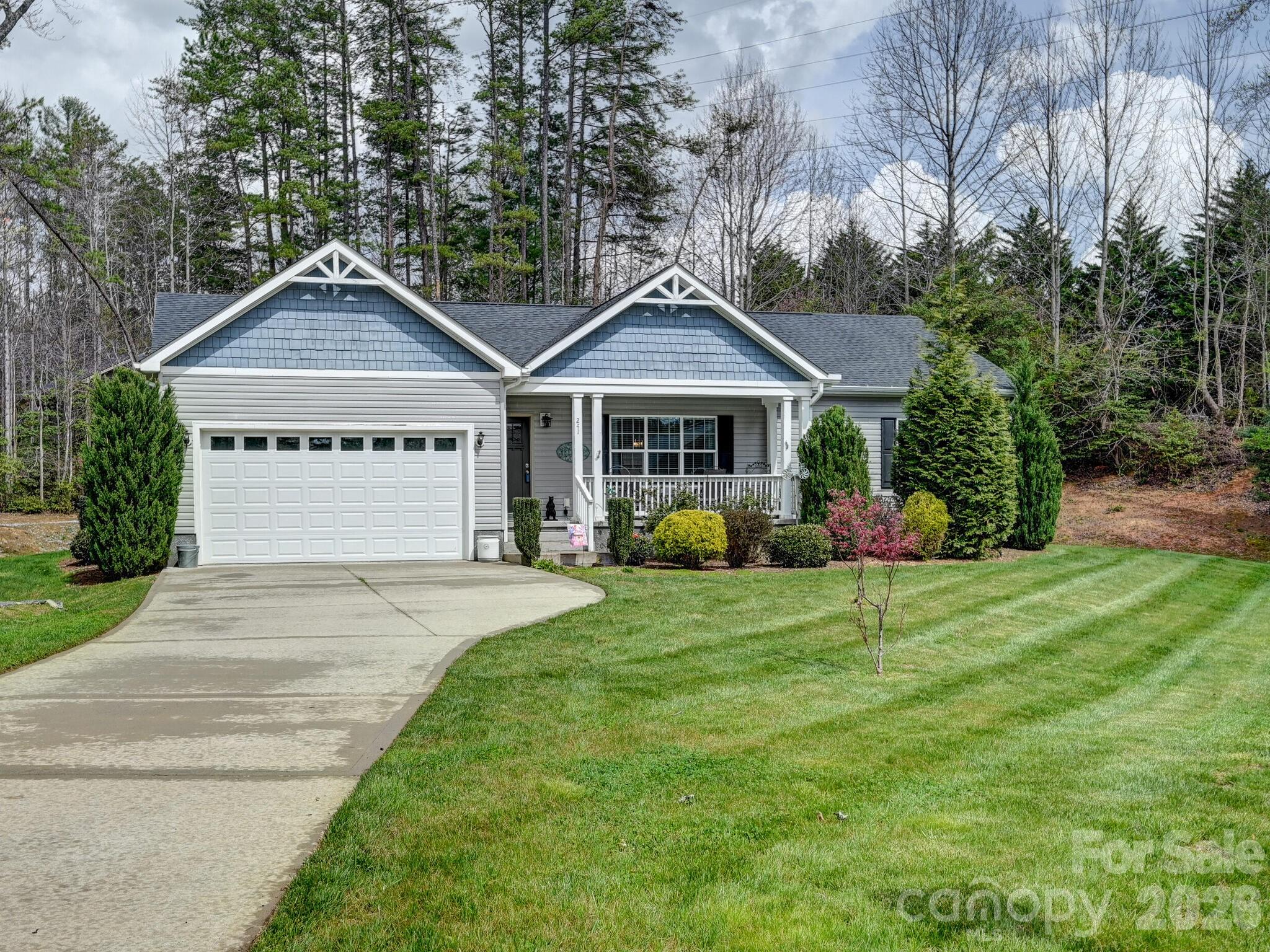 a front view of a house with a yard and trees