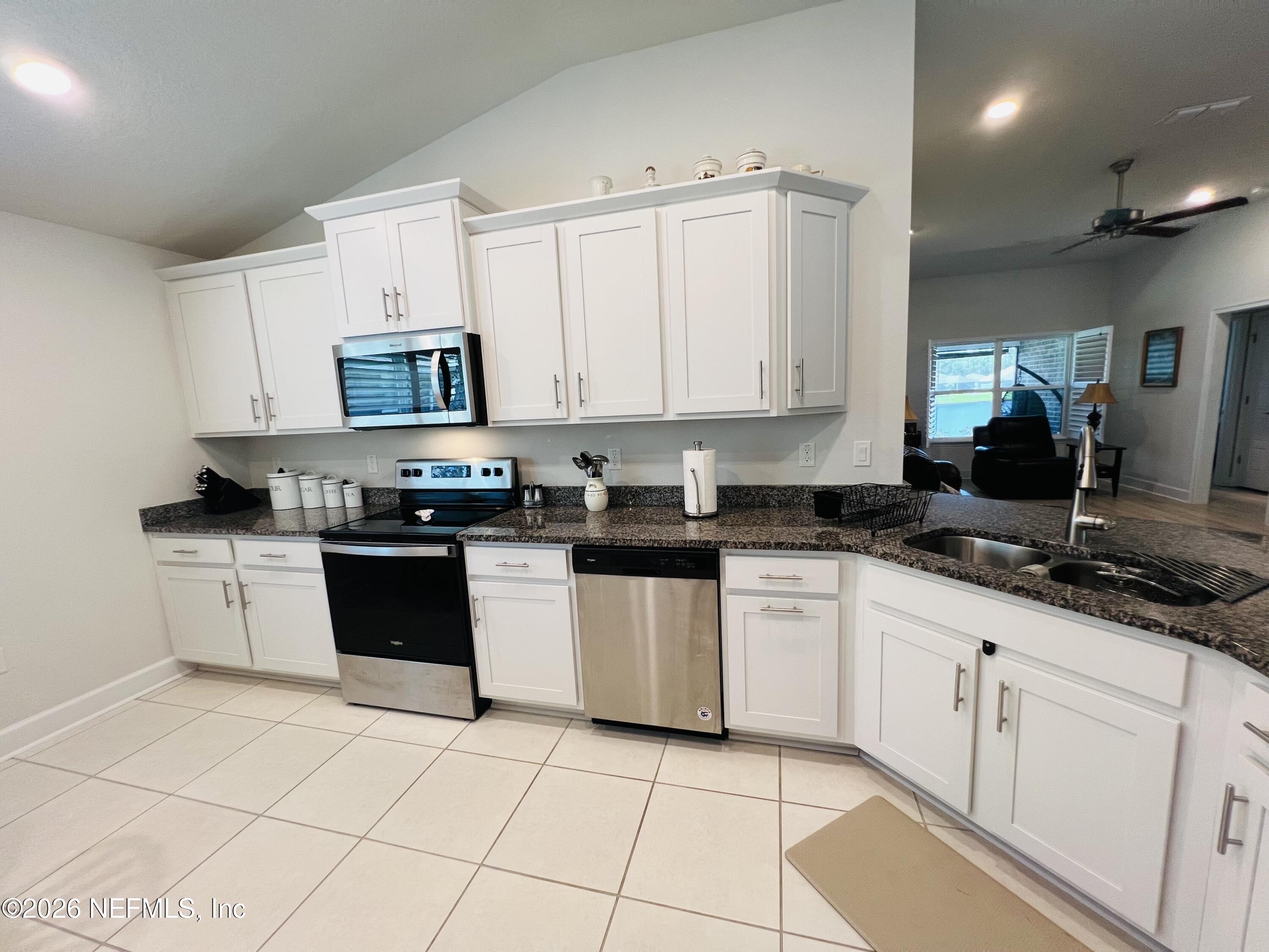 2 Rivertown Road Palm Coast, FL 32137 - Photo 36 of 80 a kitchen with stainless steel appliances granite countertop a sink a stove a microwave and cabinets