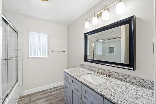 a bathroom with a granite countertop sink a mirror and a