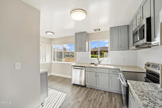 a kitchen with stainless steel appliances a sink stove and cabinets