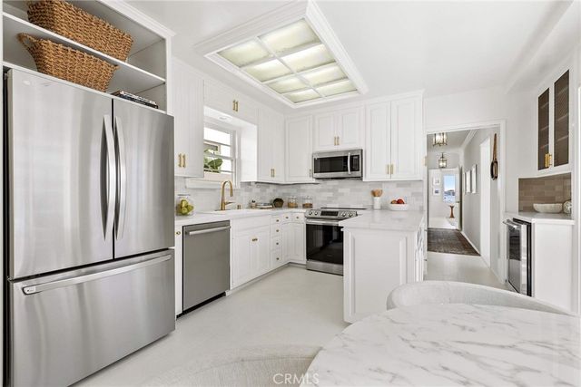 a kitchen with stainless steel appliances a refrigerator sink and microwave