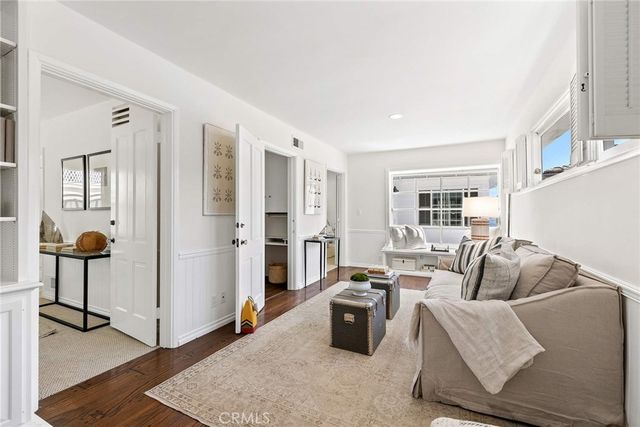a living room with furniture a lamp and wooden floor