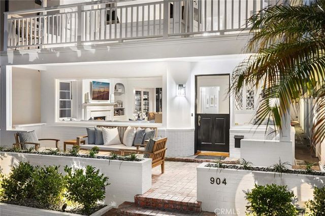 a living room with furniture a fireplace and potted plants