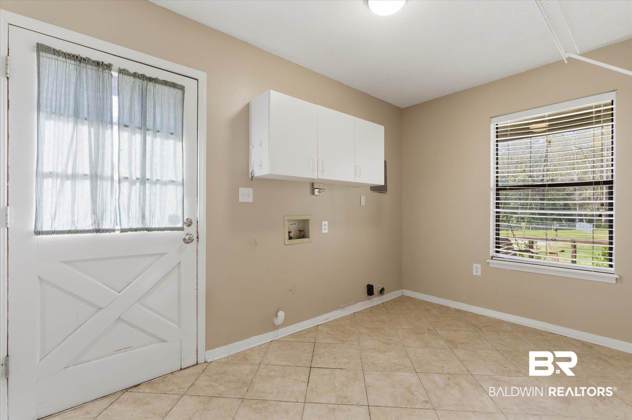 8030 Country Drive Mobile, AL 36619 - Photo 15 of 22 Laundry area with hookup for a washing machine, cabinet space, gas dryer hookup, and light tile patterned flooring