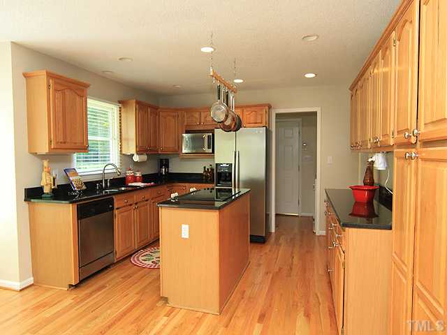 115 Equestrian Chase Rougemont, NC 27572 - Photo 4 of 12 a kitchen with stainless steel appliances granite countertop a stove a sink dishwasher and a refrigerator with wooden floor
