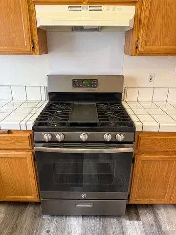 a stove top oven sitting inside of a kitchen