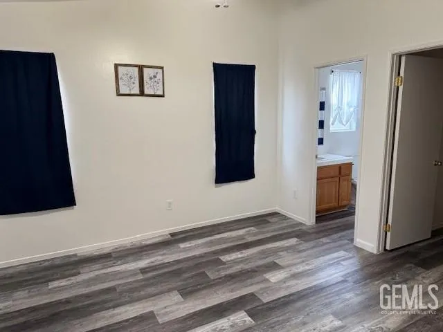 a view of an empty room with wooden floor and a cabinet