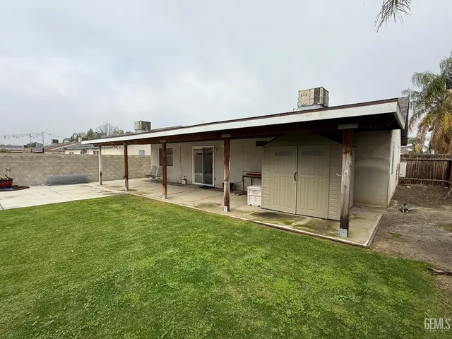 a backyard of a house with table and chairs