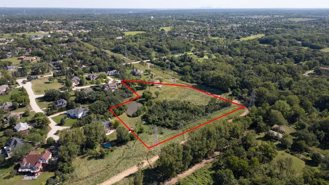 an aerial view of residential houses with outdoor space and trees