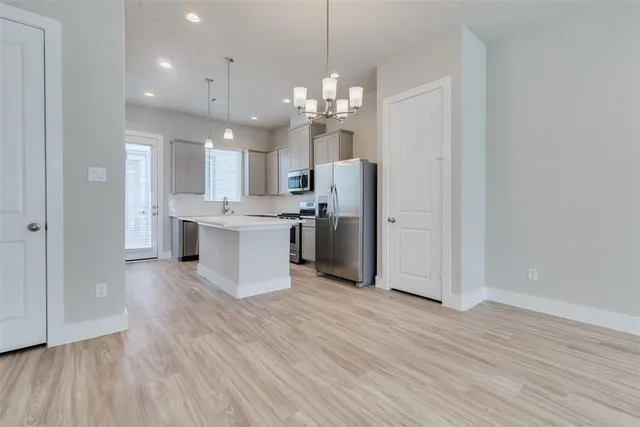 a kitchen with kitchen island a sink stainless steel appliances and cabinets