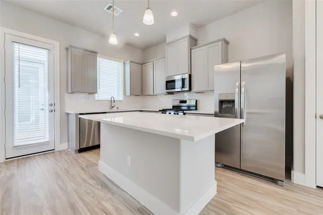 a kitchen with stainless steel appliances granite countertop white cabinets a sink and a stove