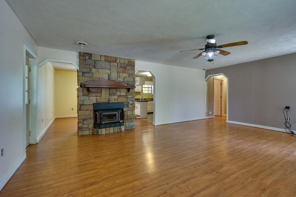 200 Coble Road Hohenwald, TN 38462 - Photo 8 of 29 a view of an empty room with wooden floor fireplace and a window