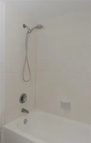 a bathroom with a bath tub with a shower