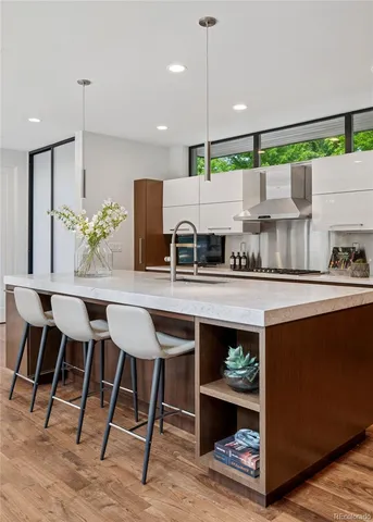 a kitchen with stainless steel appliances kitchen island granite countertop a table chairs in it and wooden floors